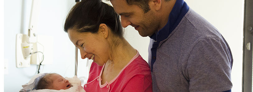 a man and a woman looking at a baby