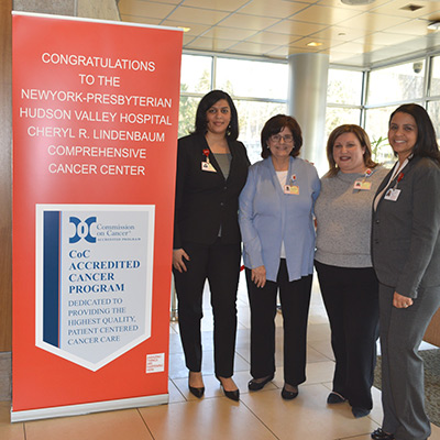 A group of women standing next to a banner