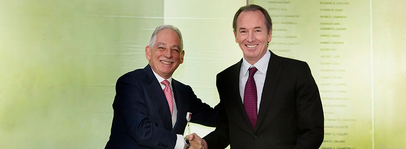 Two healthcare professionals shaking hands smiling for a photo