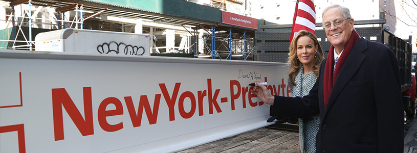 a man and a woman standing in front of a sign