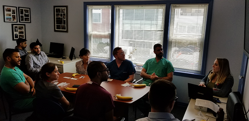 a group of people sitting in a room watching a presentation