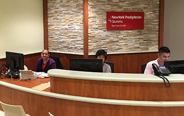 a group of people sitting at a desk with computers