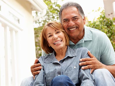 A man holding a woman as they sit on steps together