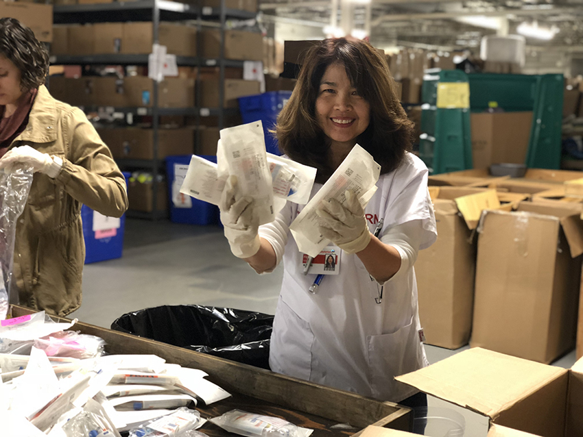 A woman holding green item donations