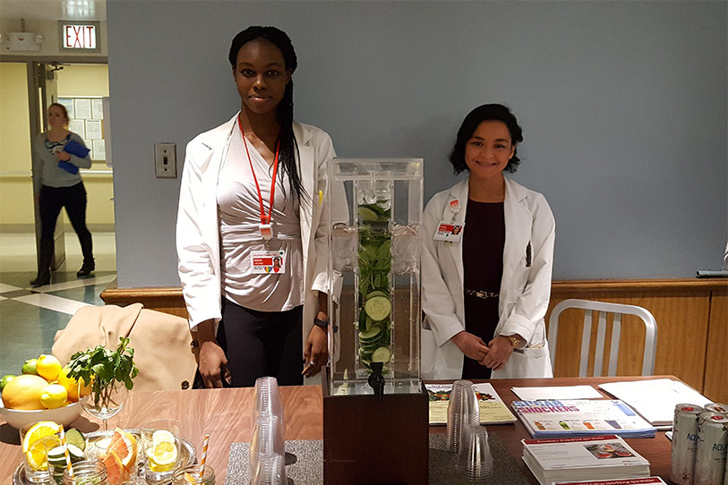 Two women standing behind a table with healthy beverages