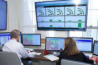 a man and a woman sitting at a desk with computers