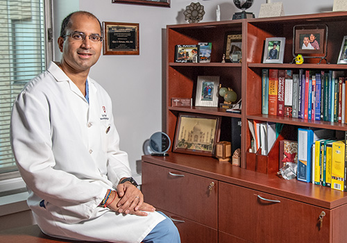 Dr. Kirtane sitting in front of bookcase