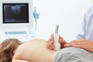 image of doctor doing an ultrasound on a child's lower back