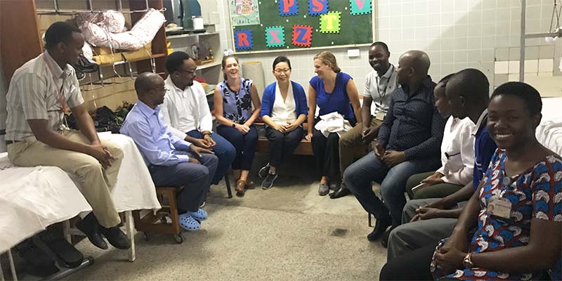 image of Dr. Heakyung Kim sitting in a semicricle with staff