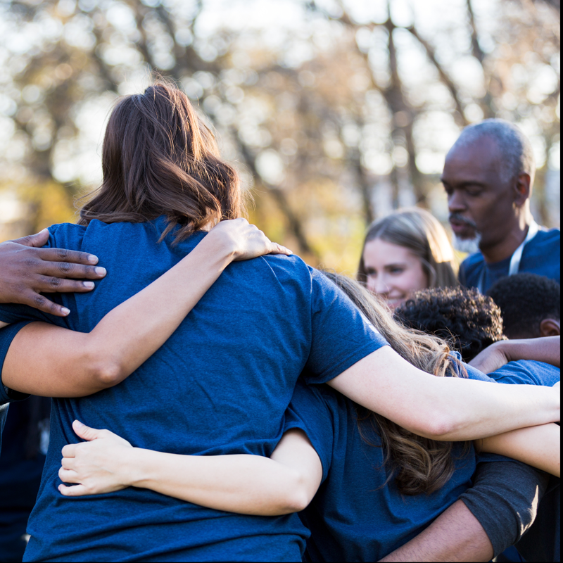 Group of corporate volunteers embracing