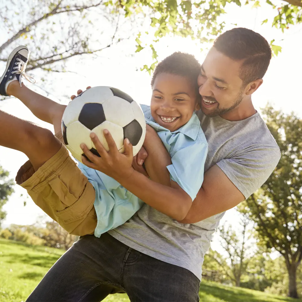 Kid holding a basketball walking with an adult