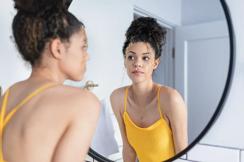 image of woman looking at herself in the mirror