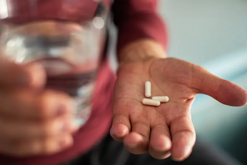 image of person holding pills in hand