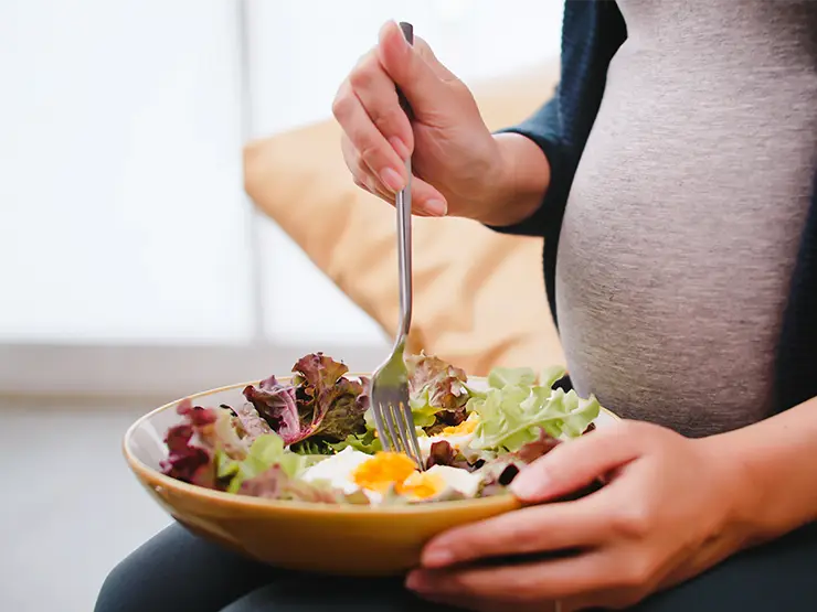 image of pregnant woman eating salad